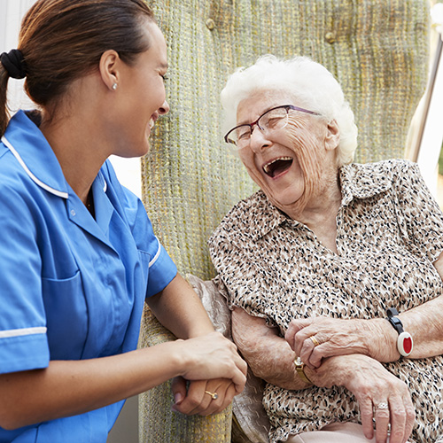Resident socializes and laughs with nurse at senior living community